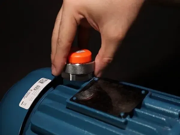 Installing a Phantom wireless sensor on the housing of an electric motor.